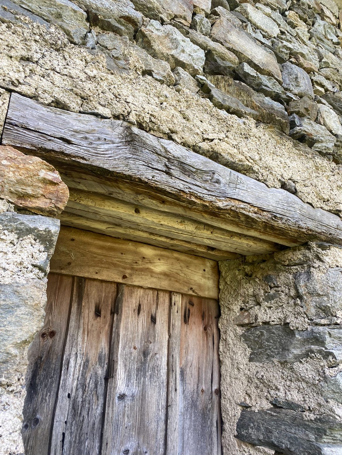 Dettaglio di muro in pietra a secco e travi di legno scuro